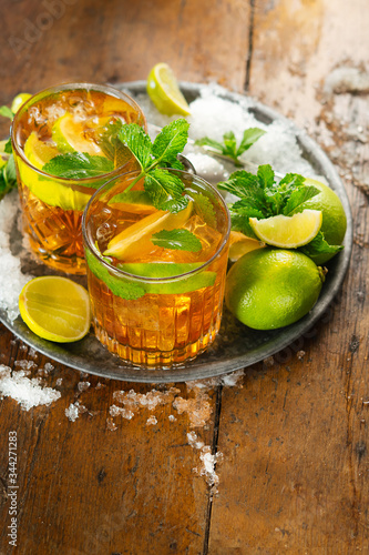 Refreshing iced drink with Lime, Mint and rum over rustic background, copy space. Top view. Refreshing cold alcoholic summer cocktail concept.