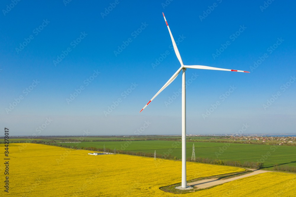 close up aerial view to single wind generator with shadow under blue sky and copy space close up aerial view to single wind generator with shadow under blue sky and copy space