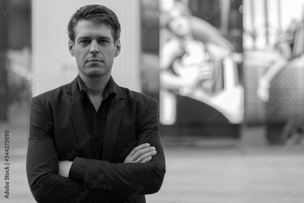 Young handsome businessman with arms crossed in the city Young handsome businessman with arms crossed in the city