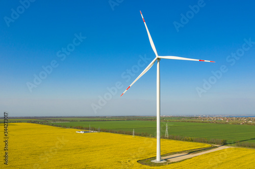 close up aerial view to single wind generator with shadow under blue sky and copy space