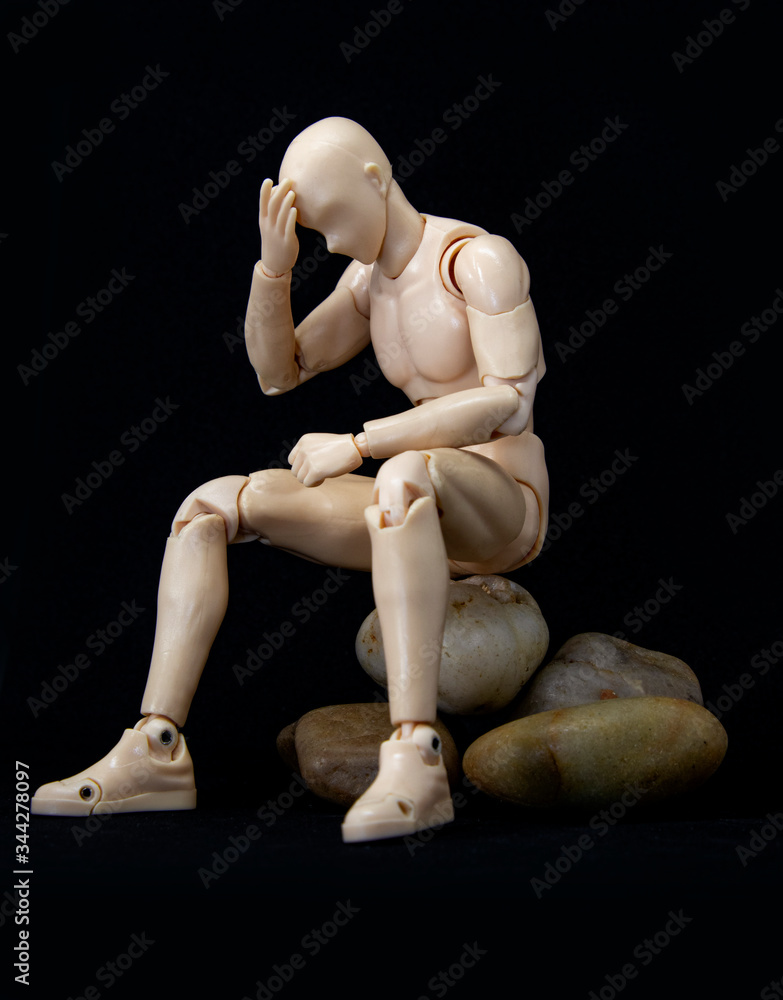 male mannequin depressed sitting alone in worried, anxious, or thoughtful state isolated on black male mannequin depressed sitting alone in worried, anxious, or thoughtful state isolated on black