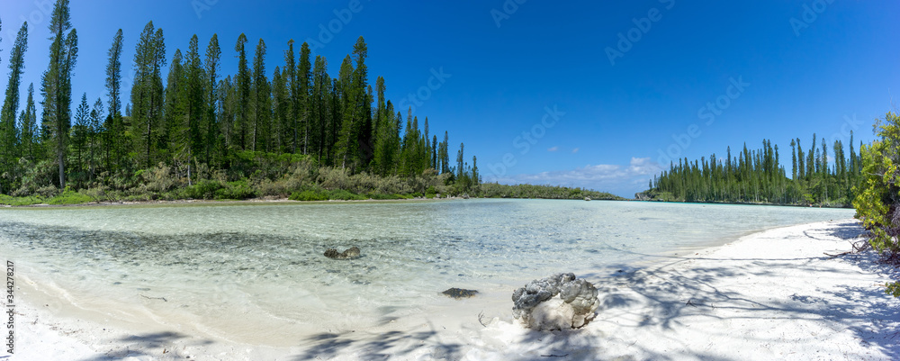 Panorama of beautiful natural swimming pool of Oro Bay, Isle of Pines, New Caledonia. sky is blue with some clouds. sea is turquoise. panoramic format
