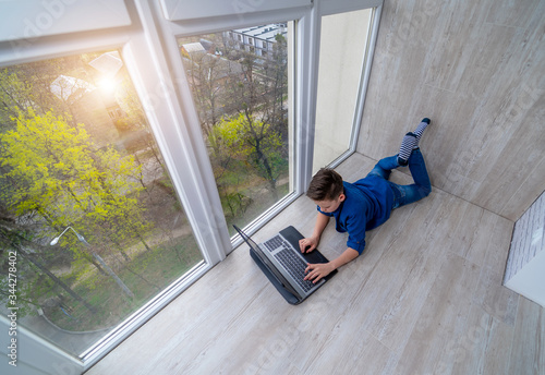 Wallpaper Mural Little boy relaxing on a terrace and surfing the net on smart phone. Torontodigital.ca