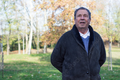 Portrait of a smiling senior man in Nature, looking away