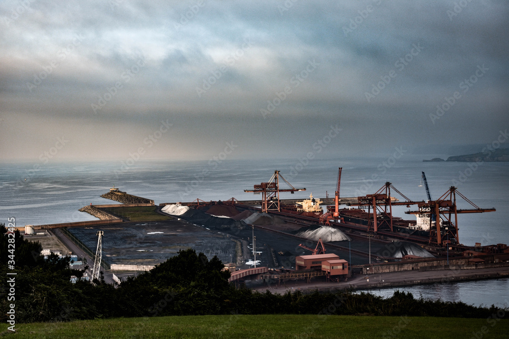 Industria junto al mar, Gijon, Asturias, España. Puerto de Gijón (El Musel), Asturias, España, con cielo nublado.