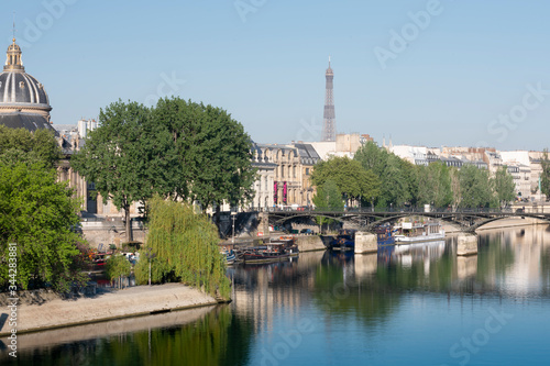 reflection in the Seine river view of the city of Paris France with morning light from a bridge 