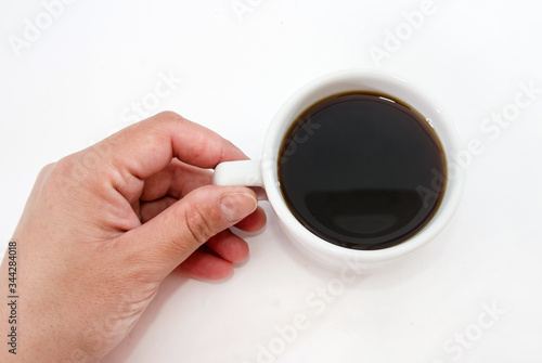 cup of black coffee in hand on a white background. View from above.