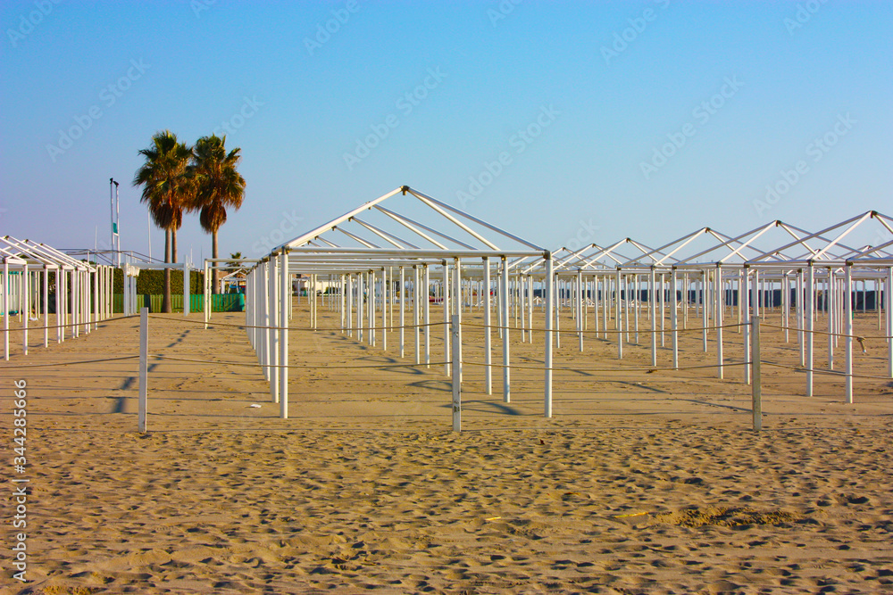 structures for desolate umbrellas and tents of unused bathing establishments alone without quarantine on the beach by the sea structures for desolate umbrellas and tents of unused bathing establishments alone without quarantine on the beach by the sea
