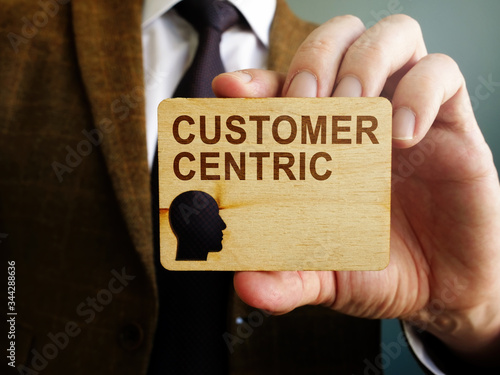 Customer centric concept. Man holds wooden plate. photo