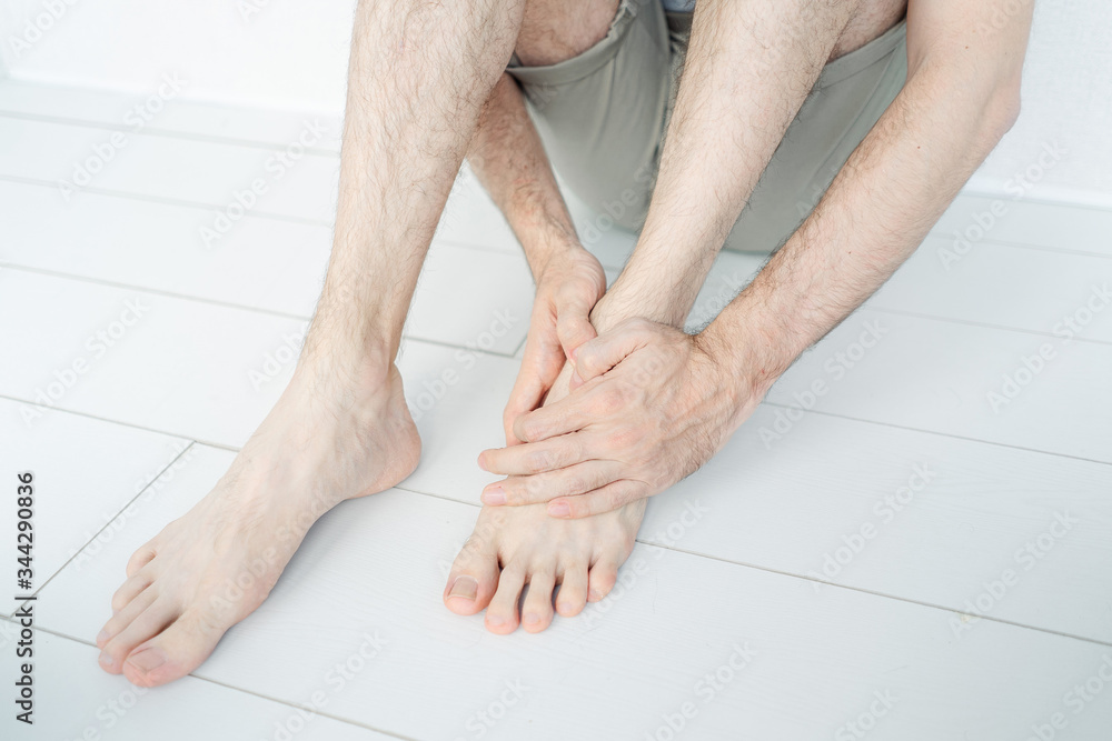 a man holds his foot, foot pain, injury, hurt a man holds his foot, foot pain, injury, hurt
