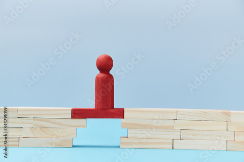 Business risk. Danger and chance. Mockup style for design. Copy space. Red wooden figures stands on plank of bridge gap