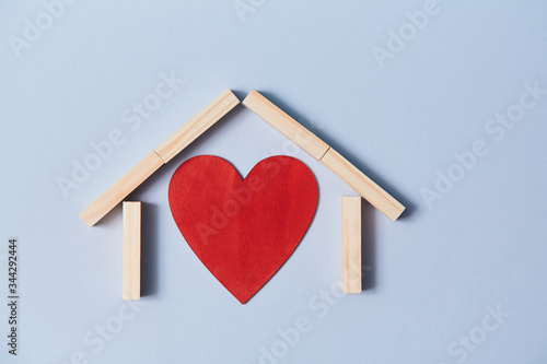 Relationship and happy family. Love or affection. Adopt child. Red heart and wooden blocks. Isolated on blue background