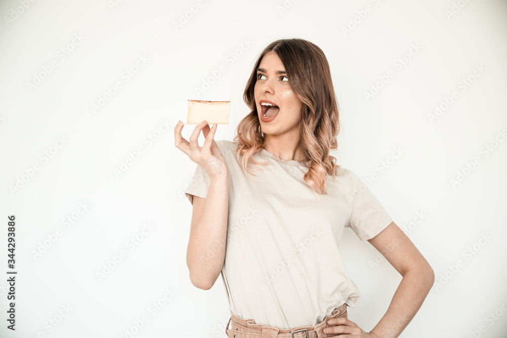 Happy and surprised young pretty girl holding a cake on a white background. The concept of eating healthy. Happy and surprised young pretty girl holding a cake on a white background. The concept of eating healthy.