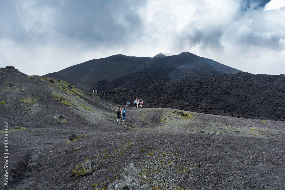 Los jóvenes están caminando hacia la cima del volcán Pacaya.
