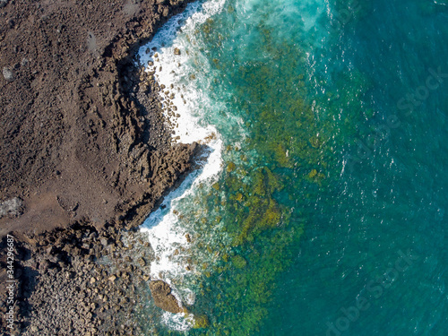 Beautiful aerial shot of turquoise water breaking on rocks in Canary Islands