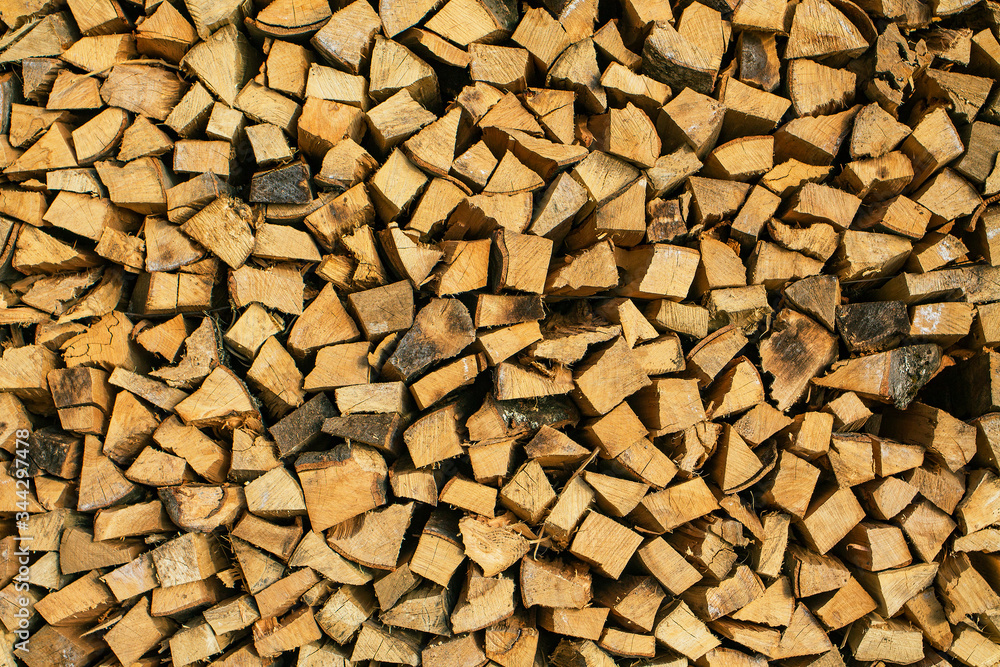 Prepared chopped wood. A stacked woodpile. Texture in the form of a wooden wall. Prepared chopped wood. A stacked woodpile. Texture in the form of a wooden wall.