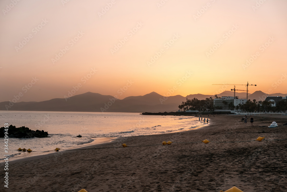 Sunset at beautiful beach in Lanzarote with view of mountains in the distance