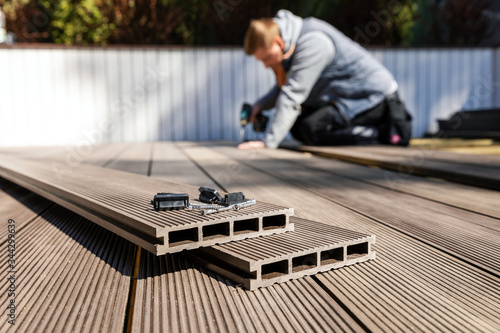Obraz na plátně wpc terrace construction - worker installing wood plastic composite decking boar