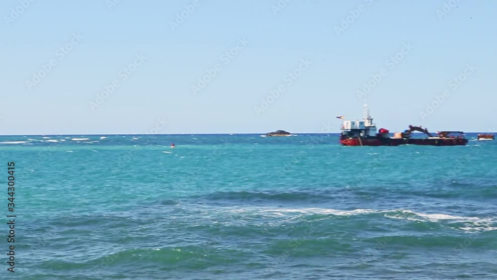 slowly panorama at seascape with white waves and large black ship