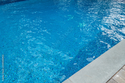 blue gound pool with wavy highlights and cement and brick circumference masonry