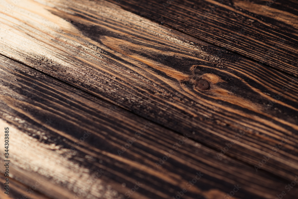 Fototapeta premium Painting a wooden surface with paint, stain. On a label or banner and advertising surface. Wooden boards are half covered with stain. The painting process, the layout.