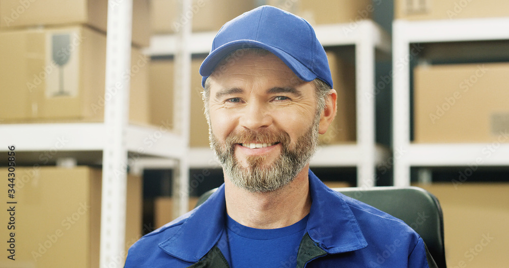 Portrait of happy delivery man in uniform and cap smiling cheerfully to camera. Portrait of happy delivery man in uniform and cap smiling cheerfully to camera.