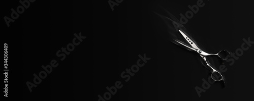 Hairdresser scissors on a black background concept