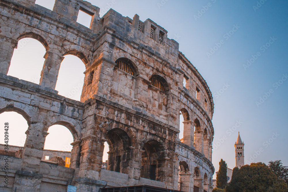 Ancient Roman Amphitheater in Pula, Istrian Peninsula in Croatia. Empty street during early morning.