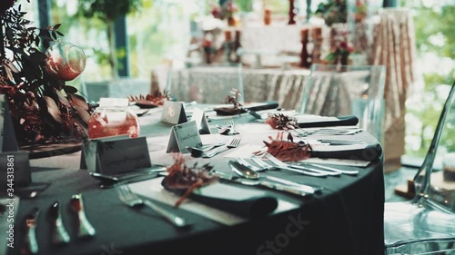 Circling filming of the round decorated with floral bright centerpiece composition table at the fancy restaurant for the birthday celebration dinner, peopleless wedding decoration of the restaurant