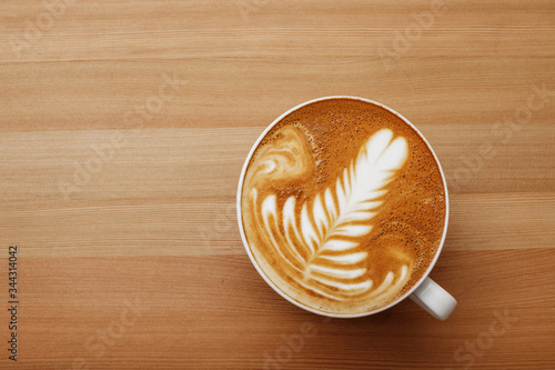 Foto Cappuccino coffee with nice and presentable plating in a white mug top view in wooden table background