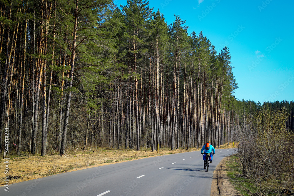 cyclist riding on the road to the forest cyclist riding on the road to the forest