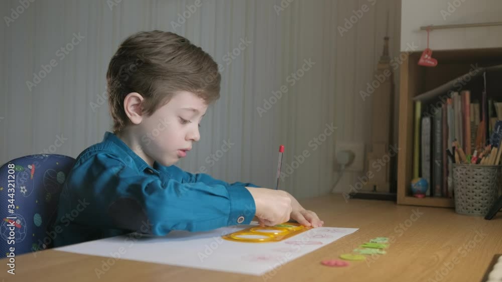 Teenager draws with red pen patterns, using the graphical ruler Teenager draws with red pen patterns, using the graphical ruler