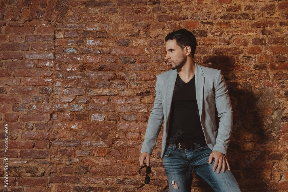 Portrait of a handsome stylish man posing in loft studio interior. Fashion for men. Portrait of a handsome stylish man posing in loft studio interior. Fashion for men.