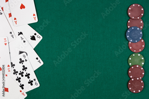 Poker cards on the left side and chips on the right side with green background on the rest of the image