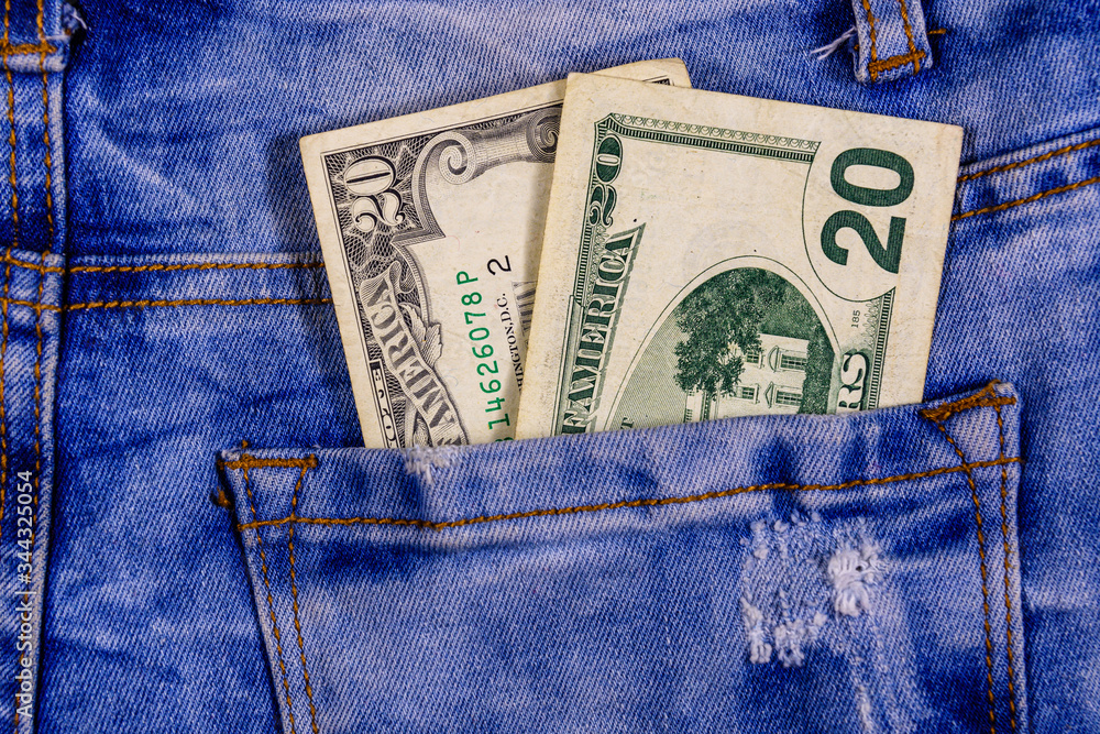 American twenty dollar banknotes in a pocket of blue jeans American twenty dollar banknotes in a pocket of blue jeans