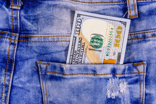 American one hundred dollar banknote in a pocket of blue jeans