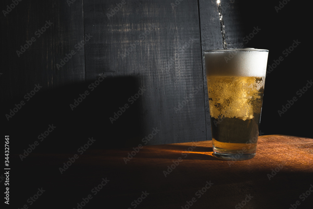 Glass with beer served on wooden table