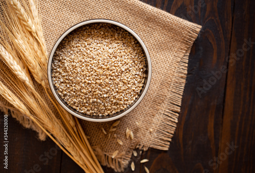 Bowl of Raw Steel Cut Oats on Burlap Fabric with Copy Space photo