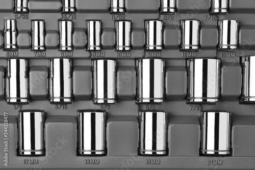 Closeup of a set of socket wrenches of various size in a plastic case.  Black and white image. photo