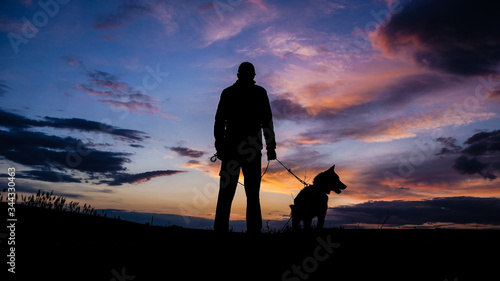 Silhouette of a hunter with a dog at sunset