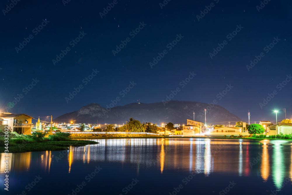 Açude Velho e Serra do Cruzeiro ao fundo na cidade de Salgueiro - Pernambuco durante uma noite estrelada.