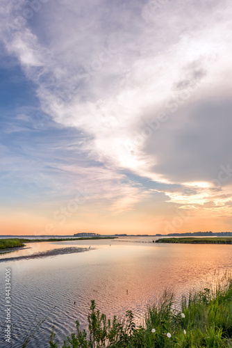 Great Blue Heron fishing on a sandbar during a beautiful Chesapeake Bay sunset at Blackwater Wildlife refuge in Maryland