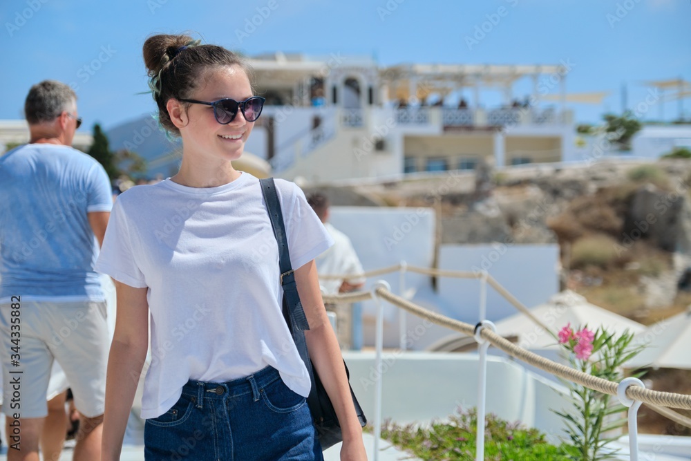 Beautiful happy girl tourist on island of Santorini in Greece