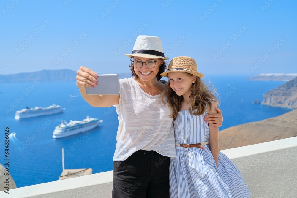 Mother and little daughter traveling together in Mediterranean, Greece, Santorini island