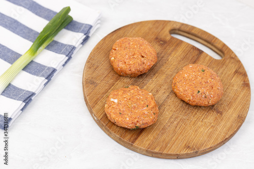Raw minced meat meatballs on the wooden board ready for frying