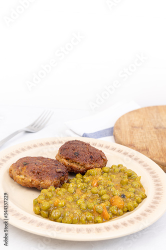 Served fried meatballs with cooked peas on the plate