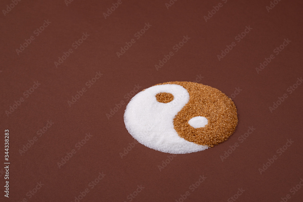 Yin yang symbol made with refined white sugar and cane sugar. Visual metaphor comparing both sugars. Cane sugar versus refined sugar. Yin yang symbol made with refined white sugar and cane sugar. Visual metaphor comparing both sugars. Cane sugar versus refined sugar.