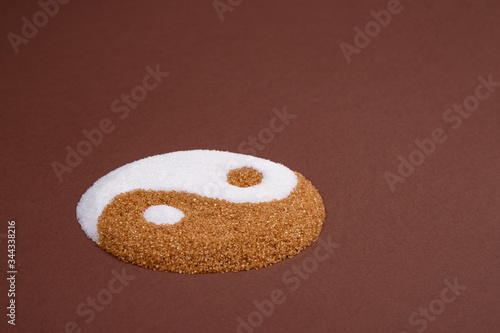 Yin yang symbol made with refined white sugar and cane sugar. Visual metaphor comparing both sugars. Cane sugar versus refined sugar.