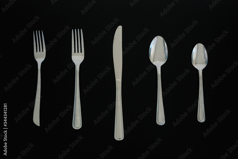 Top view of a silverware placed on a dark table Top view of a silverware placed on a dark table