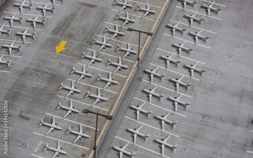 Lockdown of flights concept: Composite image of a parking lot shot from above and 3d rendered airplanes temporarily retired due to very reduced number of flights.